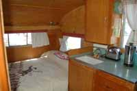 Photo shows the kitchen counter and original sink which may have the build date stamped onto the side Interior view of a vintage 1961 Shasta trailer showing the kitchen countertop and original sink, which may include the manufacture date